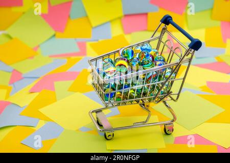 un panier avec des boules de verre décoratives sur un fond de notes adhésives en papier multicolore Banque D'Images