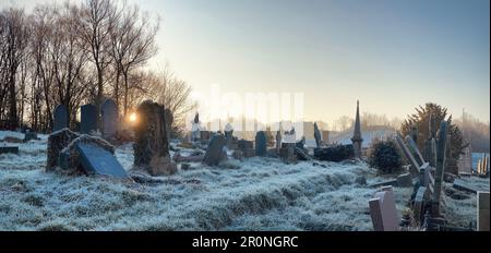 Le gel couvrait le cimetière pendant un matin hivernal dans le cimetière de l'ancienne église méthodiste sur St George's Road. En appuyant les pierres tombales à des angles étranges. Banque D'Images