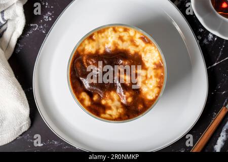 Riz au lait sur fond sombre. Dessert au riz au lait. Spécialités turques. Nom local sütlaç. Vue de dessus Banque D'Images