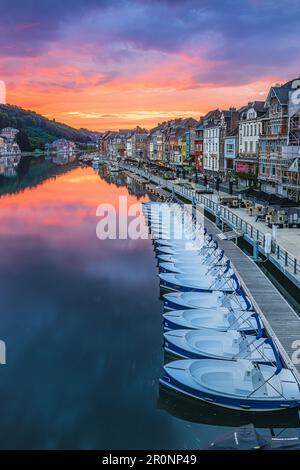 Coucher de soleil coloré en Belgique de la ville de Dinant. Rivière Maas avec maisons anciennes au bord de la rivière. Reflet de maisons et coucher de soleil sur la surface de l'eau. Banque D'Images