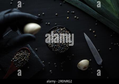 Lentilles vertes françaises (le puy lentilles vertes PDO, AOC) (Lens esculenta puyensis ) avec poireaux vue de dessus macro détail toile de fond gros plan non cuit cru, dos Banque D'Images