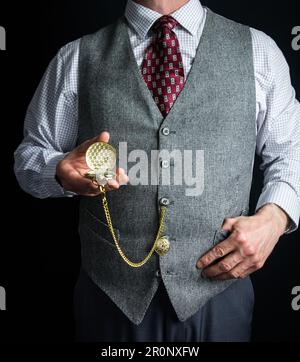 Portrait d'un homme en tweed Vest ou gilet de costume tenant une montre de poche. Style vintage et mode rétro de gentleman anglais classique. Banque D'Images