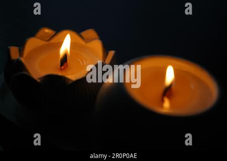 Une bougie aromatique brûle dans l'obscurité et crée une atmosphère romantique. Le feu est en feu. Un dîner romantique aux chandelles pour deux amoureux. Petite nuit romantique Banque D'Images