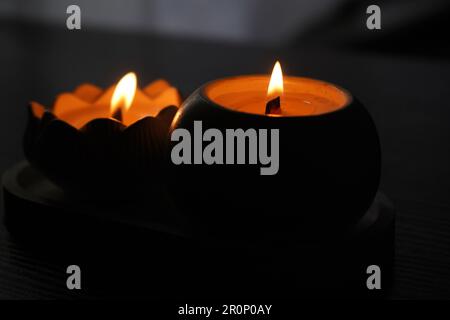 Une bougie aromatique brûle dans l'obscurité et crée une atmosphère romantique. Le feu est en feu. Un dîner romantique aux chandelles pour deux amoureux. Petite nuit romantique Banque D'Images