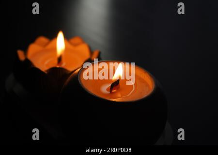 Une bougie aromatique brûle dans l'obscurité et crée une atmosphère romantique. Le feu est en feu. Un dîner romantique aux chandelles pour deux amoureux. Petite nuit romantique Banque D'Images