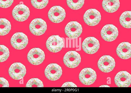 Motif composé de beignets en anneau avec glaçure blanche et de centaines et de milliers de courgeuses sur fond rouge Banque D'Images
