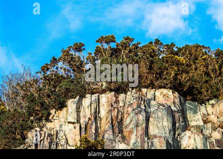 Une grande falaise rocheuse avec une végétation qui monte au sommet à Kyle de Lochalsh, en Écosse, au Royaume-Uni Banque D'Images