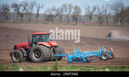 Le bruit d'un moteur de tracteur et la vue d'un cultivateur en mouvement ne peuvent signifier qu'une chose : il est temps de se préparer à la saison des semis Banque D'Images