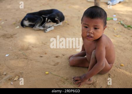 MARACAIBO-VENEZUELA-14-17-2017- Un enfant est vu assis sur le sable près d'un chien avec des signes de grippe dans un voisin pauvre dans la capitale de la Sta pétrolière Banque D'Images