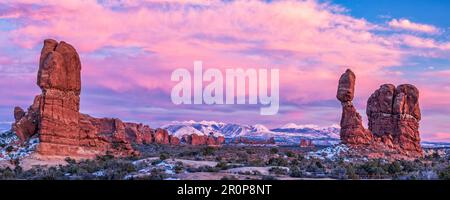 Neige fraîche sur Balanced Rock avec la section Windows et les montagnes de la Sal en arrière-plan dans le parc national d'Arches - Moab, Utah. Banque D'Images
