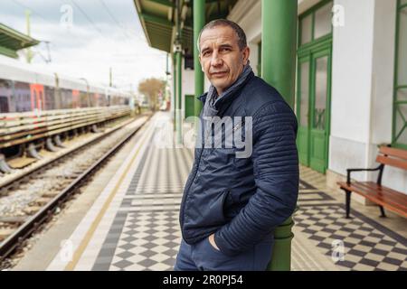 Homme d'âge moyen solitaire et charmant sur fond flou de la rue de la ville Banque D'Images