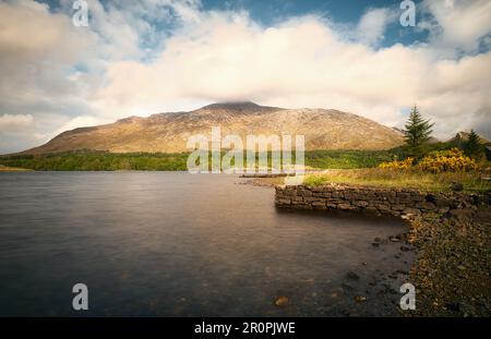 Magnifique paysage avec petite jetée en pierre au bord du lac avec des montagnes en arrière-plan à Lough Inagh dans le parc national du Connemara dans le comté de Galway, en Irlande Banque D'Images