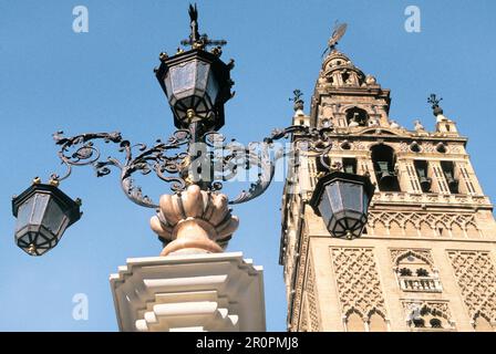 La Giralda Cathédrale Bell Tour Séville Espagne Andalousie ancienne lampe de rue ornée sur la place publique. Site historique du patrimoine mondial de l'UNESCO. Jour repère Banque D'Images