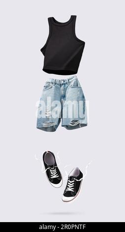 Débardeur tendance en coton volant, short jeans et baskets bleus isolés sur fond gris. Nettoyer le haut de récolte noir. Vêtements de marque. Mock up pour votre de Banque D'Images