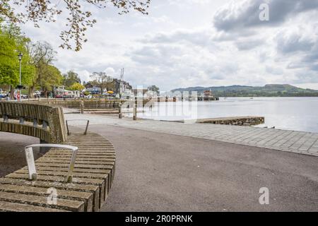 Banc incurvé vu sur le front de mer à Waterhead, à l'extrémité Ambleside du lac Windermere, photographié en mai 2023 dans le district des lacs. Banque D'Images