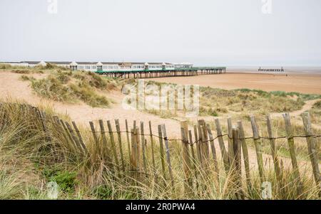 Une clôture de plage bancale vue devant les dunes de sable et la plage de St Annes-on-the-Sea vue en mai 2023. Banque D'Images