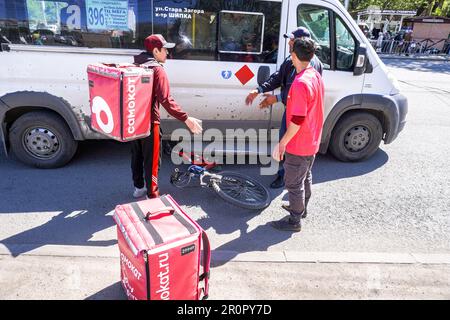 Samara, Russie - 7 mai 2023: Accident de voiture dans une rue de ville avec un cycliste d'un service de livraison. Le minibus a couru sur un cycliste d'un service de livraison Banque D'Images