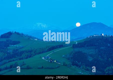 Waidhofen an der Ybbs : pleine lune s'élève à la montagne Ötscher (à gauche), hameau et église Windhag, arbres de poire en fleurs, prairies, maisons de ferme à Mostvierte Banque D'Images