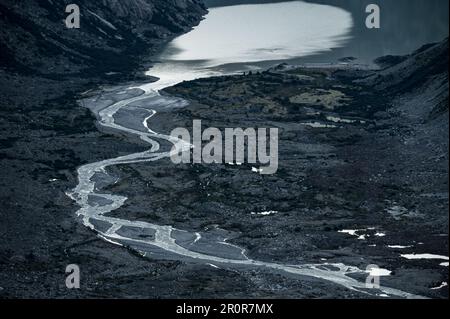 Ruisseau de meandering après Unteraargletscher avec Grimselsee lors d'une journée ensoleillée d'été Banque D'Images