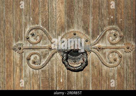 Fragment d'une vieille porte d'église avec une poignée en métal. Poignée de porte décorative ancienne. Banque D'Images