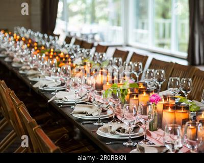 Bougies allumées et verres à vin brillants sur la table pour la fête. Réception pour mariage ou autre événement est prêt pour les clients. Banque D'Images