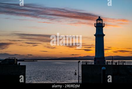 Édimbourg, Écosse, Royaume-Uni, 9th mai 2023. Météo au Royaume-Uni : coucher de soleil au port de Newhaven. Un coucher de soleil coloré au-dessus du phare silhoueté sur le Firth of Forth. Crédit : Sally Anderson/Alay Live News Banque D'Images