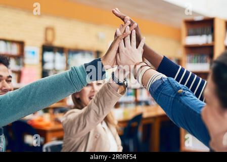 Nous mettons la tête et les mains ensemble pour faire mieux. un groupe d'étudiants universitaires en plein milieu. Banque D'Images