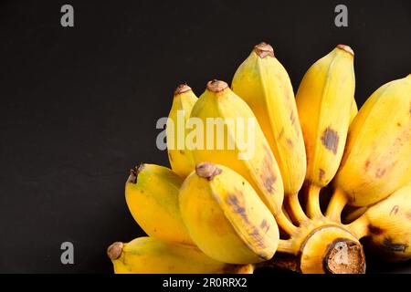 Bananes à fond noir, banane cultivée sur fond noir, banane cultivée thaï.fruits et légumes.espace de copie.banane thaï. Banque D'Images