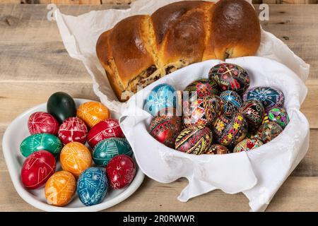 Gâteaux roumains fraîchement cuits et œufs de Pâques peints à la main. 'Cozonac' ou 'cozonaci' est fait de pâte de levure douce utilisée pour faire des holos traditionnels Banque D'Images