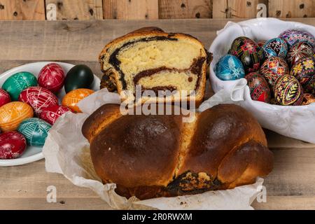 Gâteaux roumains fraîchement cuits et œufs de Pâques peints à la main. 'Cozonac' ou 'cozonaci' est fait de pâte de levure douce utilisée pour faire des holos traditionnels Banque D'Images