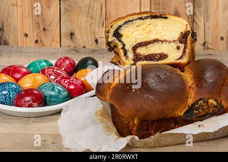 Gâteaux roumains fraîchement cuits et œufs de Pâques peints à la main. 'Cozonac' ou 'cozonaci' est fait de pâte de levure douce utilisée pour faire des holos traditionnels Banque D'Images