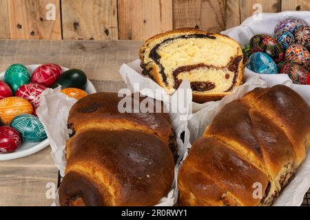 Gâteaux roumains fraîchement cuits et œufs de Pâques peints à la main. 'Cozonac' ou 'cozonaci' est fait de pâte de levure douce utilisée pour faire des holos traditionnels Banque D'Images