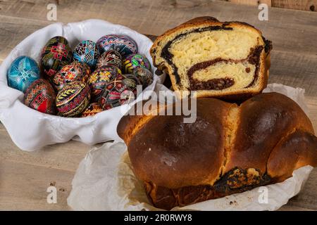 Gâteaux roumains fraîchement cuits et œufs de Pâques peints à la main. 'Cozonac' ou 'cozonaci' est fait de pâte de levure douce utilisée pour faire des holos traditionnels Banque D'Images