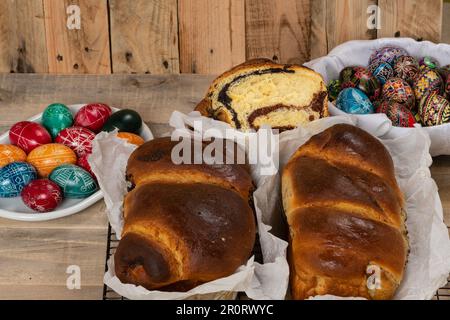 Gâteaux roumains fraîchement cuits et œufs de Pâques peints à la main. 'Cozonac' ou 'cozonaci' est fait de pâte de levure douce utilisée pour faire des holos traditionnels Banque D'Images