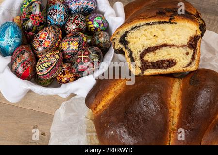 Gâteaux roumains fraîchement cuits et œufs de Pâques peints à la main. 'Cozonac' ou 'cozonaci' est fait de pâte de levure douce utilisée pour faire des holos traditionnels Banque D'Images