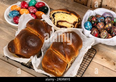 Gâteaux roumains fraîchement cuits et œufs de Pâques peints à la main. 'Cozonac' ou 'cozonaci' est fait de pâte de levure douce utilisée pour faire des holos traditionnels Banque D'Images