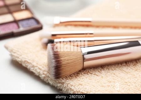 Nettoyer les brosses de maquillage avec une serviette sur la table blanche, en gros plan Banque D'Images