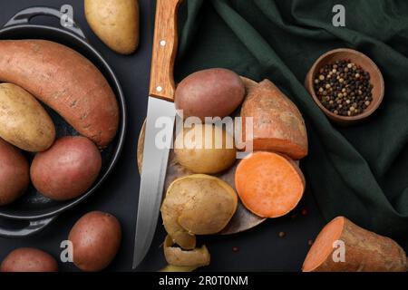 Différents types de pommes de terre fraîches sur une table noire, à plat Banque D'Images