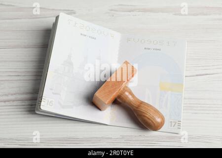 Ukraine, Lviv - 6 septembre 2022: Passeport et visa sur table en bois blanc, vue de dessus Banque D'Images