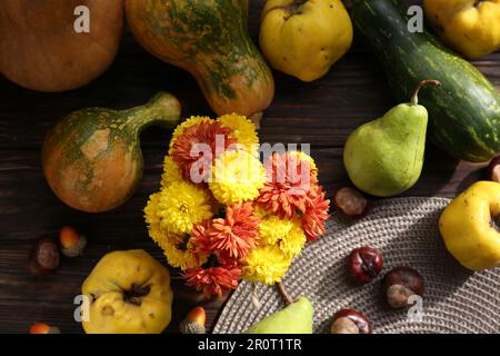 Composition de la couche plate d'automne avec de belles fleurs de chrysanthème et des citrouilles sur une table en bois Banque D'Images