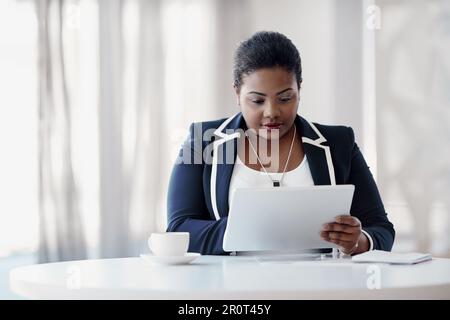 La technologie des tablettes est le meilleur ami des femmes d'affaires. une jeune femme d'affaires attirante qui utilise sa tablette au bureau. Banque D'Images