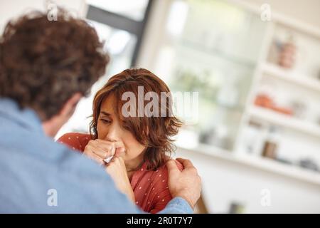 Ce que je vais faire. une femme étant réconfortée par son mari comme elle pleure. Banque D'Images