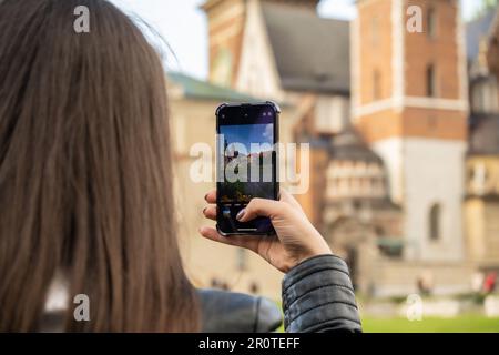 Une femme voyageur dans des lieux historiques regarde autour de la cour d'un monument et tourne de courtes vidéos au téléphone. Photos touristiques lieu historique le jour ensoleillé. Femme méconnaissable Tourisme et blogging partage en ligne pour le public Voyage ensemble enregistrement vidéo sur téléphone mobile Banque D'Images