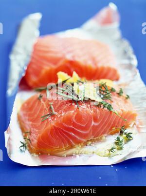 La préparation d'un épais morceau de saumon pour être cuit en papillote Banque D'Images