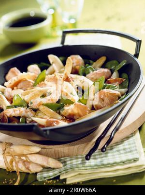 Langoustines asperges,sucre,les pois et les graines de sésame cuits dans un wok Banque D'Images