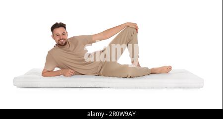 Homme allongé sur un matelas doux sur fond blanc Banque D'Images