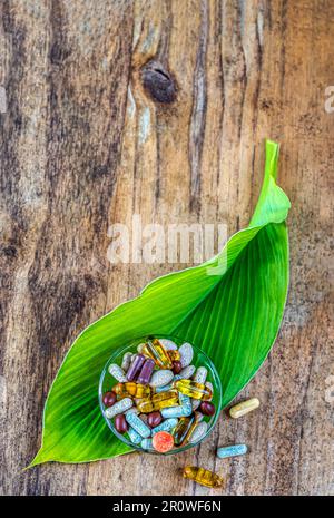 Capsules avec des compléments alimentaires en vrac dans un bol Banque D'Images