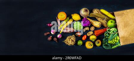 Sac d'épicerie avec des légumes et des fruits sains sur un fond noir Banque D'Images