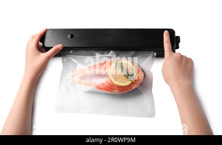 Femme utilisant un scelleuse sous vide sur fond blanc, vue de dessus. Saumon avec citron en paquet Banque D'Images