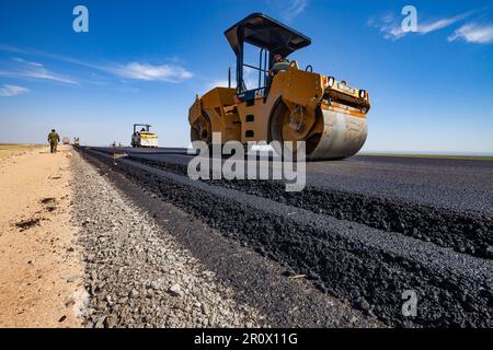 Province de Kyzylorda, Kazakhstan, 29 avril 2012 : construction de la route Europe occidentale-Chine occidentale. Le compacteur tandem vibrant Caterpillar aplatit les couches d'asphalte Banque D'Images